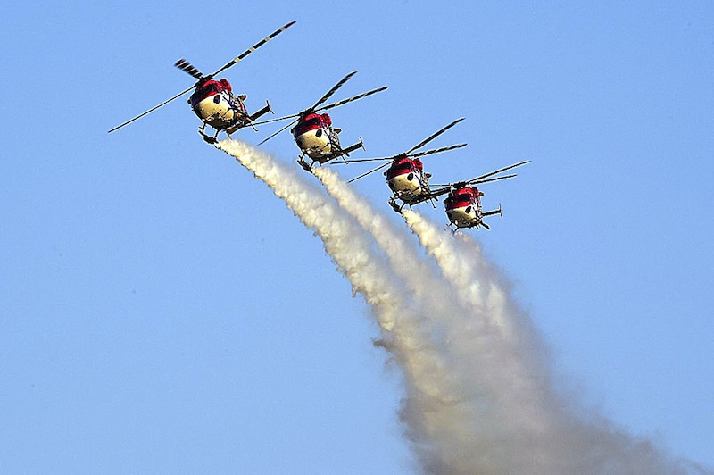 Indian Air Force (IAF) advanced light helicopters display team "Sarang" perform during an airshow at the Defence Expo 2022, in Ahmedabad on October 19, 2022.