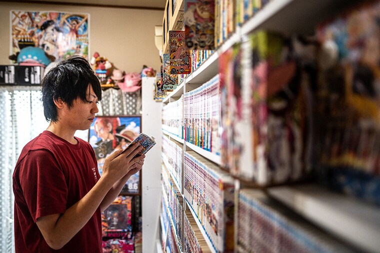 Japanese manga series "One Piece" fan Shohei Sato reads a copy of the comics in his house in Tokyo.. Photography Philip Fong / AFP