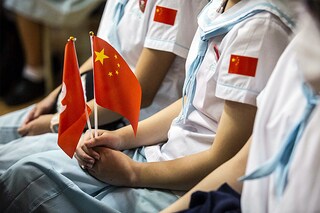 In this file photo taken on October 1, 2021, a student holds a Chinese and Hong Kong flag during a flag-raising ceremony to mark China"s National Day at a school in the Tung Chung district of Hong Kong. Image: ISAAC LAWRENCE / AFP