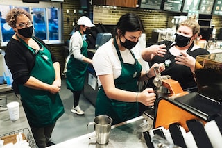Starbucks baristas in training at a location in Cheektowaga, N.Y., Oct. 13, 2021. The coffee giant intends to increase automation at its stores and open thousands of additional locations in China over the next three years. (Libby March/The New York Times)