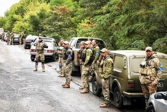 Ukrainian troops take a break on a battle-scarred road as they head to a front line, in the Kharkiv region on September 13, 2022. Ukrainian forces have recaptured dozens of towns in a stunning shift in battleground momentum, liberating over 6000 sq km in the east and south of the country this month.