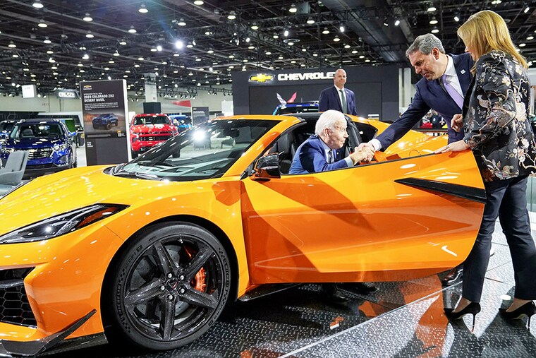 US President Joe Biden is helped out of an electric Chevrolet by General Motors President Mark Reuss as GM CEO Mary Barra looks on during a visit to the Detroit Auto Show to highlight electric vehicle manufacturing in America, in Detroit, Michigan on September 14, 2022.