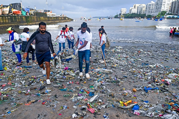 Volunteers collect trash litters during a beach clean-up campaign along the coast of Arabian Sea as part of the "International Coastal Clean-up Day" in Mumbai on September 17, 2022.