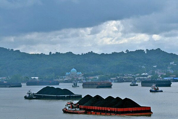 In this picture taken on August 16, 2022, piles of coal are seen on barges in Samarinda, East Kalimantan, Borneo. IEA called for international finance centres to channel funding and expertise more quickly to coal-dependent nations in order to accelerate their low-carbon transition. Image: Adek Berry/AFP 