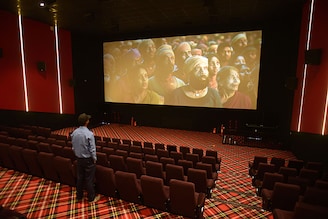 A security guard watches a trial run of a Bollywood movie ahead of the inauguration of the Inox multiplex in Srinagar, which will mark the opening of a multiplex in Kashmir after 33 years. Most cinemas in the state have remained closed for over three decades amid conflict.