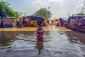 Residents living along the bank of the Yamuna river relocated to higher grounds as the water level started to flow above the danger level on September 27, 2022, in New Delhi, India. Water levels in the Yamuna on Tuesday shot past the evacuation mark of 206m, said the Delhi government, prompting authorities to move thousands of people who live along the river"s floodplains to safe places. The river is expected to swell further on Wednesday, added officials.