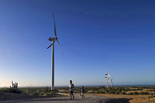 Indigenous Wayuu children walk next to the windmills of the Guajira 1 Eolic Rnergy project near the Cabo de la Vela in Uribia, department of La Guajira, Colombia. Wayuu indigenous are leading a quixotic fight against multinationals that see Colombia"s far north as a renewable energy mine. Image: Joaquin Sarmiento/ AFP) Indigenous Wayuu children walk next to the windmills of the Guajira 1 Eolic Rnergy project near the Cabo de la Vela in Uribia, department of La Guajira, Colombia. Wayuu indigenous are leading a quixotic fight against multinationals that see Colombia"s far north as a renewable energy mine. Image: Joaquin Sarmiento/ AFP)
