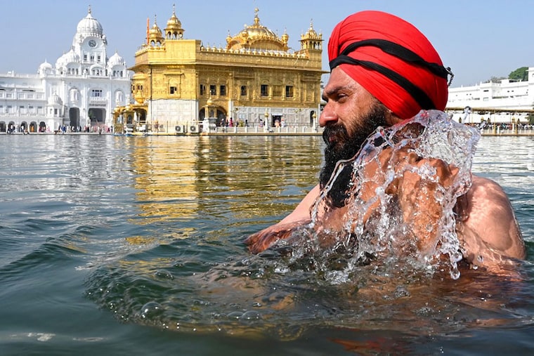 A Sikh devotee takes a dip in the holy sarovar at the Golden Temple during "Baisakhi" a spring harvest festival, in Amritsar on April 14, 2023
