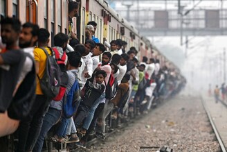 Commuters travel in an overcrowded train passing Loni railway station in Uttar Pradesh on April 24, 2023. India is set to overtake China as the world"s most populous country by the end of June, UN estimates, posing huge challenges to a nation with limited infrastructure and insufficient jobs for millions of young people.