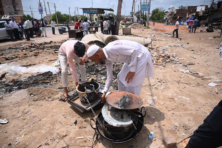People retrieve their belongings after communal clashes, near Ambedkar Chowk at Sohna, in Gurugram district on Tuesday, Aug. 1, 2023. Four people, including two home guards, died, and many others were injured in Nuh, where mobs tried to stop a Vishva Hindu Parishad procession, while a naib imam was killed at a mosque in Gurugram.