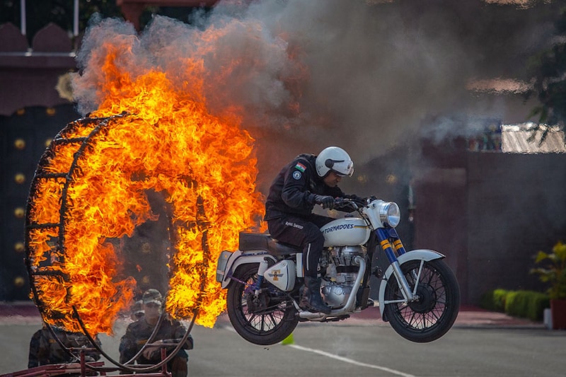 A member of the ASC motorcycle display team Tornadoes performs during the passing out parade of the first batch of Agniveer soldiers at the ASC Centre & College on August 04, 2023, in Bengaluru, India. Agnipath is a new recruitment scheme for personnel below the rank of commissioned officers into the three wings of the defence forces in India, where recruits will be hired for a maximum of four years. This scheme, approved in June 2022, has been criticised for not providing pensions and other benefits, bypassing long tenures and lack of public debates before its implementation. Personnel recruited under this scheme are called Agniveer.