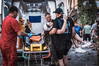 This handout photograph taken and released by Ukrainian Emergency Service on August 7, 2023, shows rescuers carrying a wounded woman following Russian missile strikes in Pokrovsk, Donetsk region.