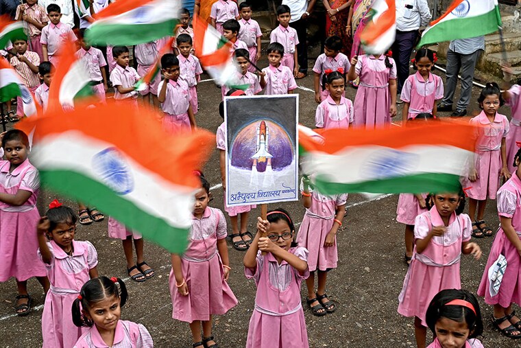 Students wave India"s national flag as they gather in support of the Chandrayaan-3 spacecraft in Mumbai on August 22, 2023. The Indian Space Research Organisation (ISRO) has confirmed that the lander module of the Chandrayaan-3 which means "Mooncraft" in Sanskrit, had "successfully separated" from the propulsion module six days ahead of a planned landing which slated for August 23. India launched a rocket on July 14 carrying an unmanned spacecraft to land on the Moon, its second attempt to do so, as its space programme seeks to reach new heights.