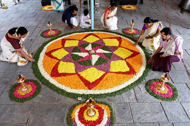 Devotees prepare Pookalam, a traditional floral arrangement, as they celebrate the "Onam" festival at Ayyappa Temple in Hyderabad on August 29, 2023.