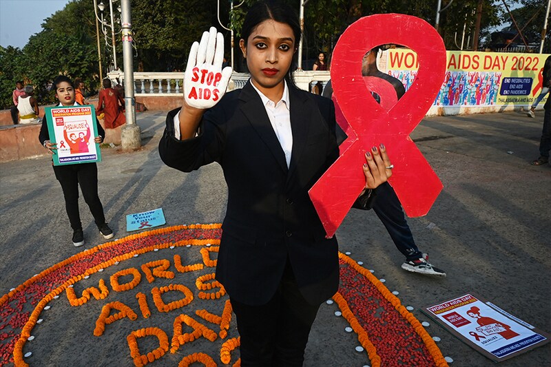 Social activists holding placards cut out in the shape of a ribbon—the red ribbon symbolising the fight against HIV AIDS—participate in an awareness campaign organised to observe World AIDS Day in Kolkata on December 1, 2022.