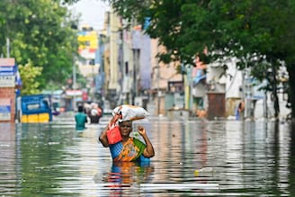 Along with her belongings, a woman wades through a flooded street after heavy rains in Chennai on December 6, 2023. Chest-high water surged down the streets of India"s southern city, Chennai, on December 5, with eight people killed in intense floods as Cyclone Michaung made landfall on the southeast coast.