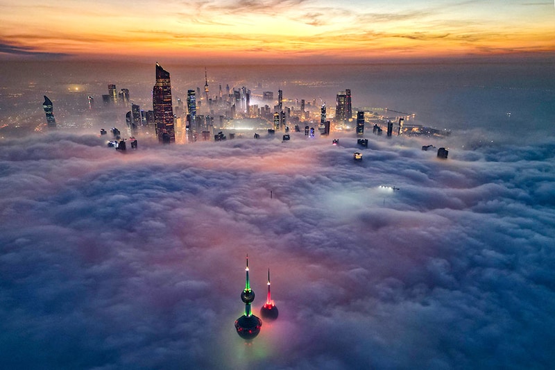 In this aerial view, the landmark Kuwait Towers and other skyscrapers pierce through the cloud cover over Kuwait City on December 10, 2023.