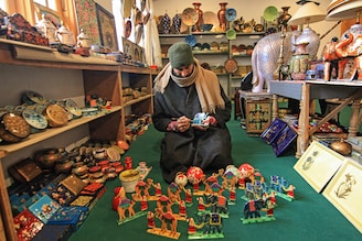 A Kashmiri artisan hand crafts a papier-mache Christmas gift item at his workshop in Srinagar, Kashmir, on December 16, 2023. These Christmas gift items made of papier-mache are being sent to local markets and also exported to the US, Italy, Germany, France, Canada, Australia, Hong Kong, and many other parts of the world ahead of Christmas celebrations. Image: Faisal Khan/NurPhoto via Getty Images