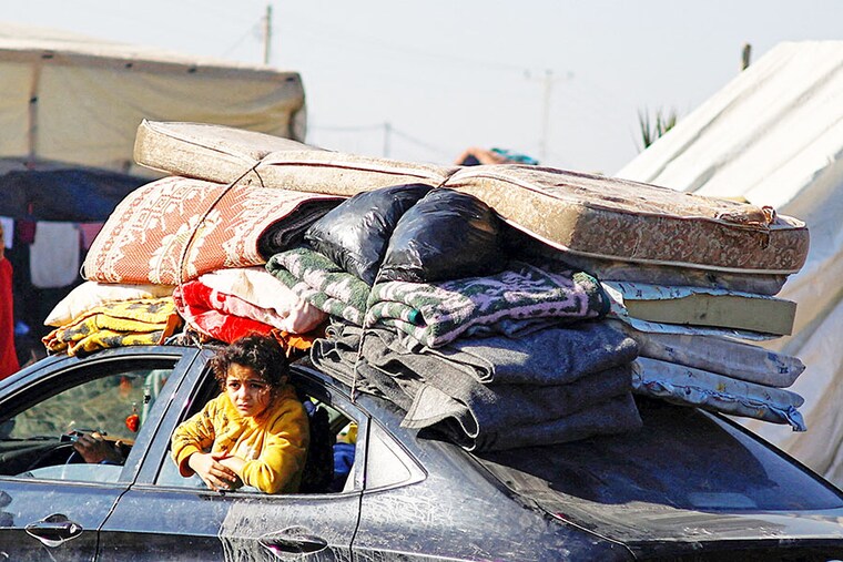 A person looks out from a car window as displaced Palestinians, who fled their houses due to Israeli strikes, shelter in a tent camp, amid the ongoing conflict between Israel and the Palestinian Islamist group Hamas, in Rafah in the southern Gaza Strip, December 26, 2023.