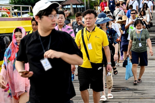 Chinese tourists prepare to board a fast boat for their trip from Serangan Island to Lombok Island in Denpasar, on Indonesia"s resort island of Bali, on January 25, 2023.
Image: Sonny Tumbelaka/ AFP