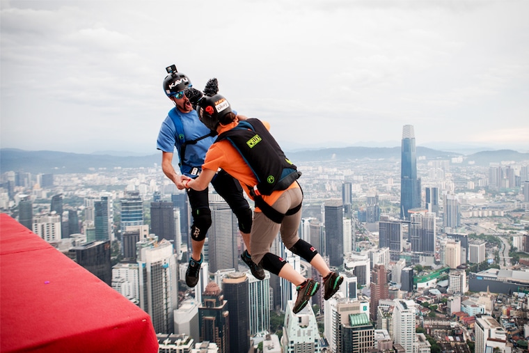 Two professional base jumpers take a leap during the KL Tower International Jump, a three-day event, in Kuala Lumpur, Malaysia, on February 3, 2023. Image: Getty Images