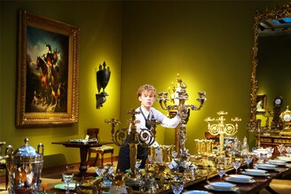 A gallery assistant poses with items on the dining table at Christie"s auction house, which forms the part of "An Opulent Aesthetic" collection in London, United Kingdom. It is an important private collection from an English country house that will be auctioned on February 09, 2023, at Christie"s. Image: Dinendra Haria/Anadolu Agency via Getty Images
