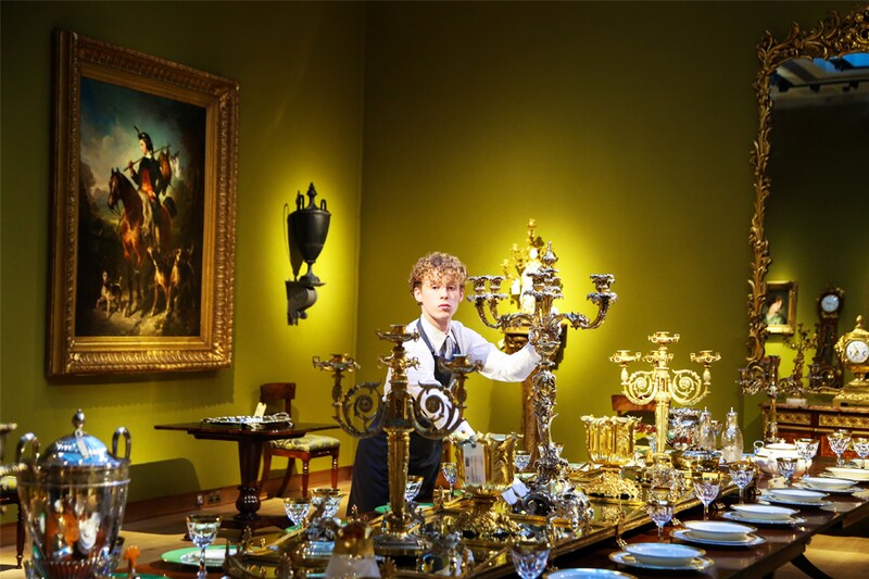 A gallery assistant poses with items on the dining table at Christie"s auction house, which forms the part of "An Opulent Aesthetic" collection in London, United Kingdom. It is an important private collection from an English country house that will be auctioned on February 09, 2023, at Christie"s. Image: Dinendra Haria/Anadolu Agency via Getty Images