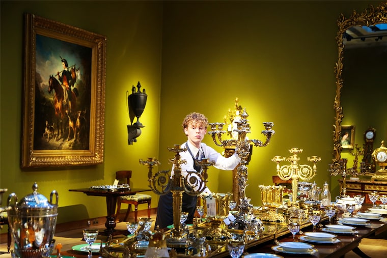 A gallery assistant poses with items on the dining table at Christie"s auction house, which forms the part of "An Opulent Aesthetic" collection in London, United Kingdom. It is an important private collection from an English country house that will be auctioned on February 09, 2023, at Christie"s. Image: Dinendra Haria/Anadolu Agency via Getty Images