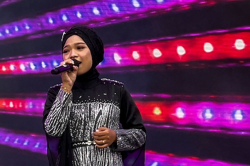 Makhi, a member of the all-female hijab-clad Nasida Ria band, performing on stage in front of an audience at a festival in Jakarta
Image: Agnes Anya / AFP