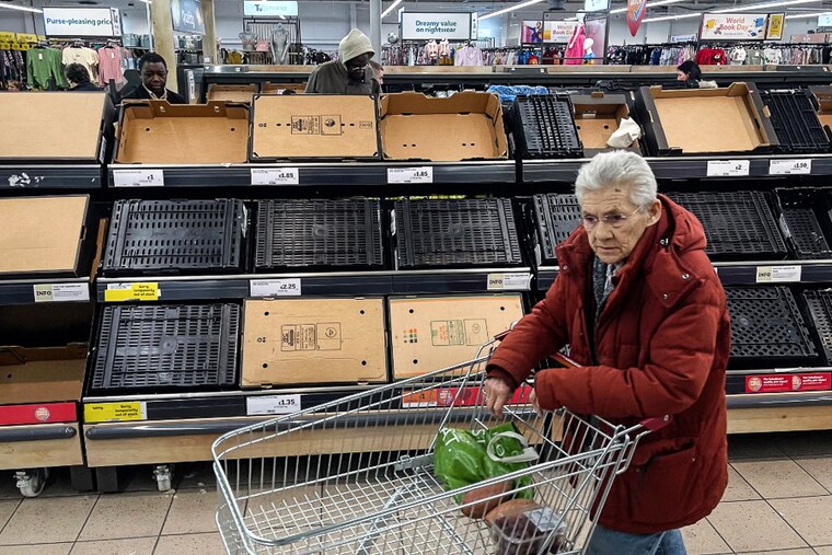 A customer walks past empty shelves at a Sainsbury supermarket, in East London, on February 24, 2023. Some UK supermarkets have introduced limits on customer purchases of some fruit and vegetables due to "sourcing challenges" blamed on weather conditions in southern Europe and north Africa.