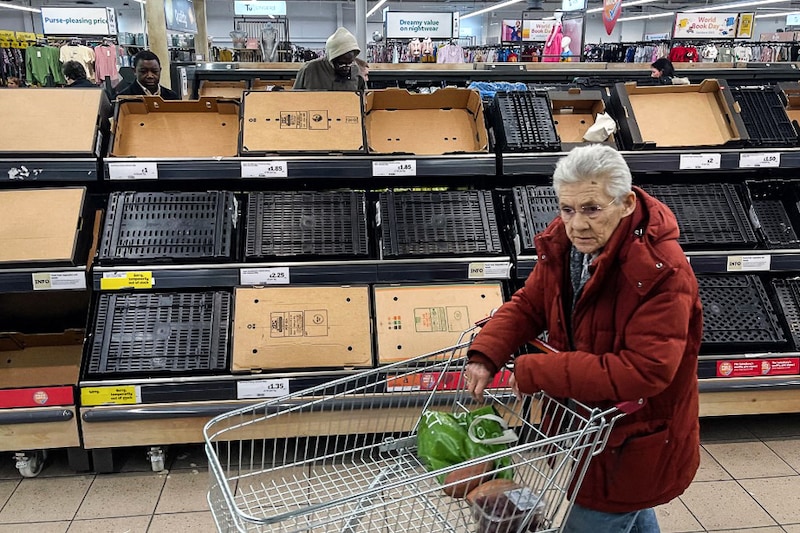 A customer walks past empty shelves at a Sainsbury supermarket, in East London, on February 24, 2023. Some UK supermarkets have introduced limits on customer purchases of some fruit and vegetables due to "sourcing challenges" blamed on weather conditions in southern Europe and north Africa.