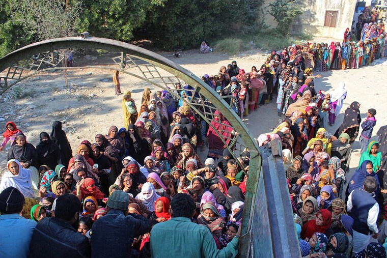 Local residents gather to purchase government-priced wheat flour at Hyderabad in Sindh province, Pakistan on January 9, 2023. The UN chief called on January 9 for "massive investments" to help Pakistan recover from last year"s devastating floods and better resist climate change. International donors pledged over $9 billion to help the country. Among the donors were Islamic Development Bank ($4.2 billion), World Bank ($2 billion), Saudi Arabia ($1 billion), as well as the EU and China