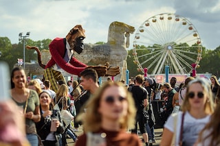 A showman manoeuvre an oversized figure in the form of a gorilla through the crowd at the Lollapalooza Festival in the Berlin Olympic Park Photo by Gregor Fischer/picture alliance via Getty Images