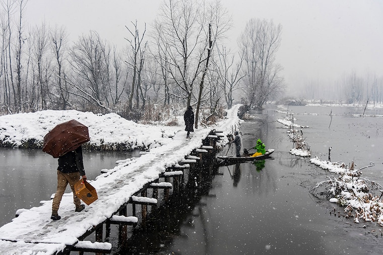 People walk on a snow-covered bridge as a boatman rows his boat under it during the snowfall in Srinagar. The Kashmir valley received a fresh snowfall that disrupted the normal lives of people. Flight operations, surface transport, and routine activities came to a grinding halt. Electricity was also affected in many areas of Kashmir. Jammu and Kashmir administration on Monday issued an alert of a high-danger level avalanche in several regions in the next 24 hours.