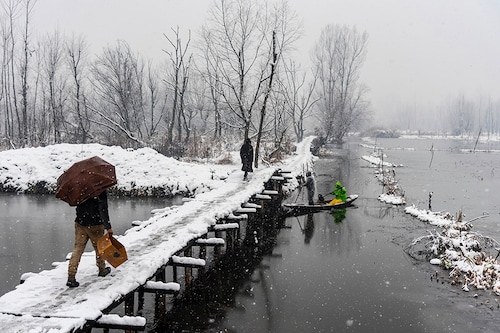 People walk on a snow-covered bridge as a boatman rows his boat under it during the snowfall in Srinagar. The Kashmir valley received a fresh snowfall that disrupted the normal lives of people. Flight operations, surface transport, and routine activities came to a grinding halt. Electricity was also affected in many areas of Kashmir. Jammu and Kashmir administration on Monday issued an alert of a high-danger level avalanche in several regions in the next 24 hours.