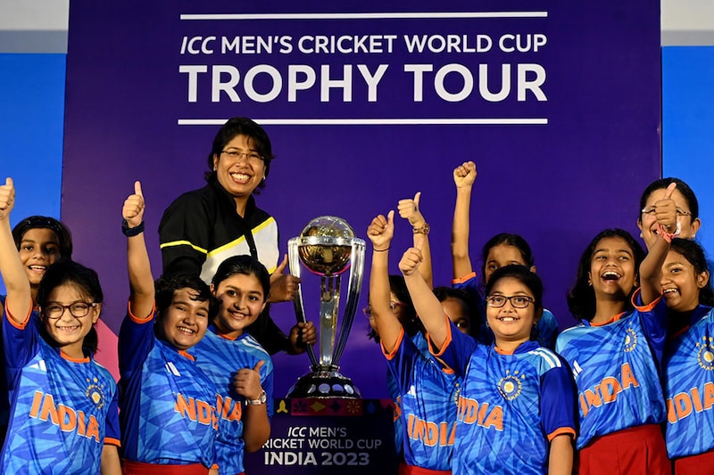 Students, with former Indian women cricketer Jhulan Goswami, cheer next to the trophy of the International Cricket Council ICC Men"s World Cup, during a tour of the trophy at a school in Kolkata on July 6, 2023.