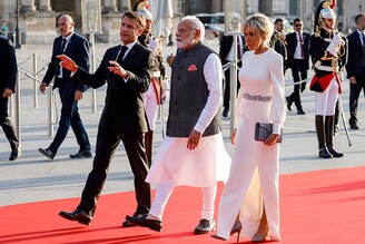 France"s president Emmanuel Macron and his wife, Brigitte, welcome India"s Prime Minister Narendra Modi (C) as they walk to a dinner at The Louvre Museum in Paris on July 14, 2023.