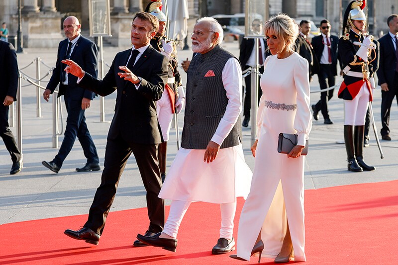 France"s president Emmanuel Macron and his wife, Brigitte, welcome India"s Prime Minister Narendra Modi (C) as they walk to a dinner at The Louvre Museum in Paris on July 14, 2023.
