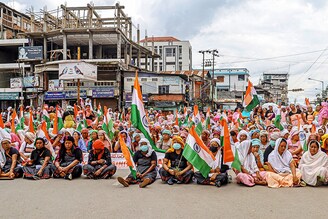 Women holding national flags participate in a demonstration demanding the restoration of peace in India"s north-eastern Manipur state in Imphal on July 17, 2023, following ongoing ethnic violence in the state.