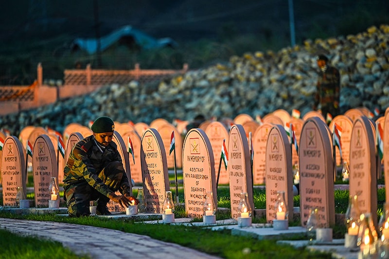 Soldiers light candles at Kargil War Memorial in memory of the soldiers who laid down their lives during the 1999 Kargil War ahead of Kargil Vijay Diwas on July 25, 2023 in Drass, India.