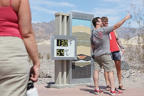 In Death Valley, tourists flock to take pictures of the extreme temperature readings. Image: RONDA CHURCHILL / AFP