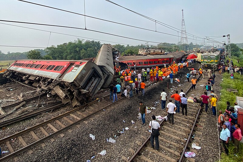 People gather at the accident site of a three-train collision near Balasore, about 200 km (125 miles) from the Odisha state capital Bhubaneswar, on June 3, 2023. At least 207 people were killed, more than 850 more were injured and many others are feared trapped after a horrific three-train collision late, local officials said.