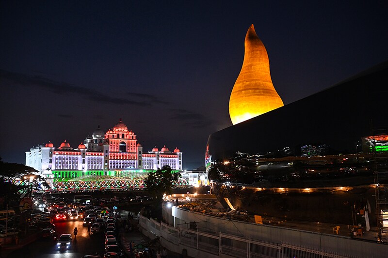 Telangana"s state New Secretariat (L) building is seen illuminated with the colours of the Indian flag next to the New Martyrs Memorial (R) on the occasion of Telangana Formation Day in Hyderabad on June 2, 2023. Image: Noah Seelam / AFP