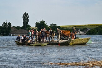 Ukrainian servicemen evacuate local residents on a barge from the flooded village of Afanasiyivka, Mykolaiv region, after water level in the Inhulets River increased following damage sustained to the Kakhovka hydroelectric power plant dam in Chornobaivka, Kherson region.