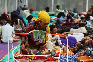 Laxmi Kumar places her three-year-old son Arvind inside a cradle at a temporary shelter for people evacuated from Kandla port before the arrival of the severe cyclone Biparjoy, in Gandhidham, in the western state of Gujarat, India on June 13, 2023.