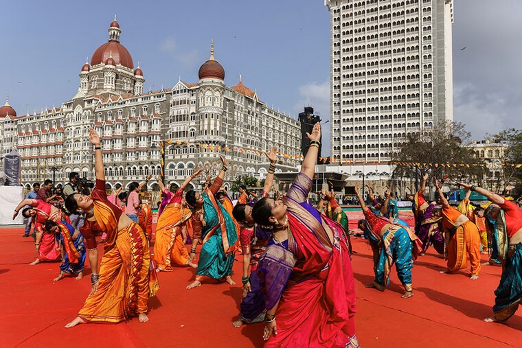 People perform yoga in front of the Taj Hotel during International Yoga Day in Mumbai, India, June 21, 2023.