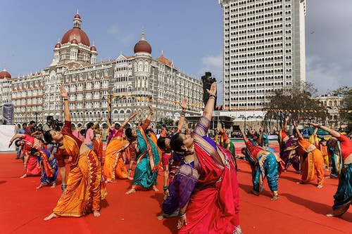 People perform yoga in front of the Taj Hotel during International Yoga Day in Mumbai, India, June 21, 2023.