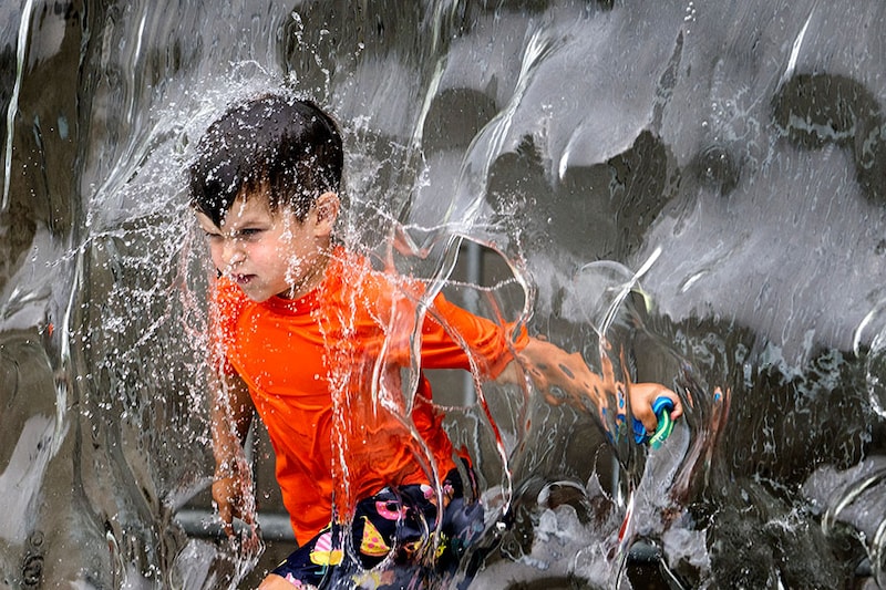A young boy plays in the water fountain at Yards Park in Washington, DC, on June 26, 2023 as a heatwave settles in on the area.
