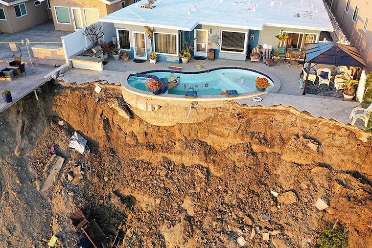 An aerial view of a remaining pool at the edge of a hillside landslide brought on by heavy rains, which caused four ocean-view apartment buildings to be evacuated and shuttered due to unstable conditions, on March 16, 2023, in San Clemente, California. Weeks of rains loosened the soil in Orange County which tumbled down near railroad tracks, that runs next to the beach below.