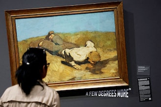 A visitor of the Leopold museum looks at the painting " A boy at the spring " by Albin Egger Lienz after the museum tilted 15 of its paintings in protest of climate change in Vienna, Austria, March 22, 2023.